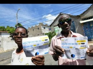 Valerie & Rudolph holding their JPS bills