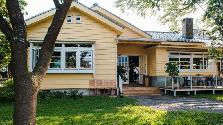 charming-yellow-house-with-wooden-windows-green-grassy-garden